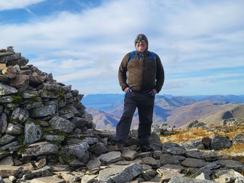 Man standing beside cairn